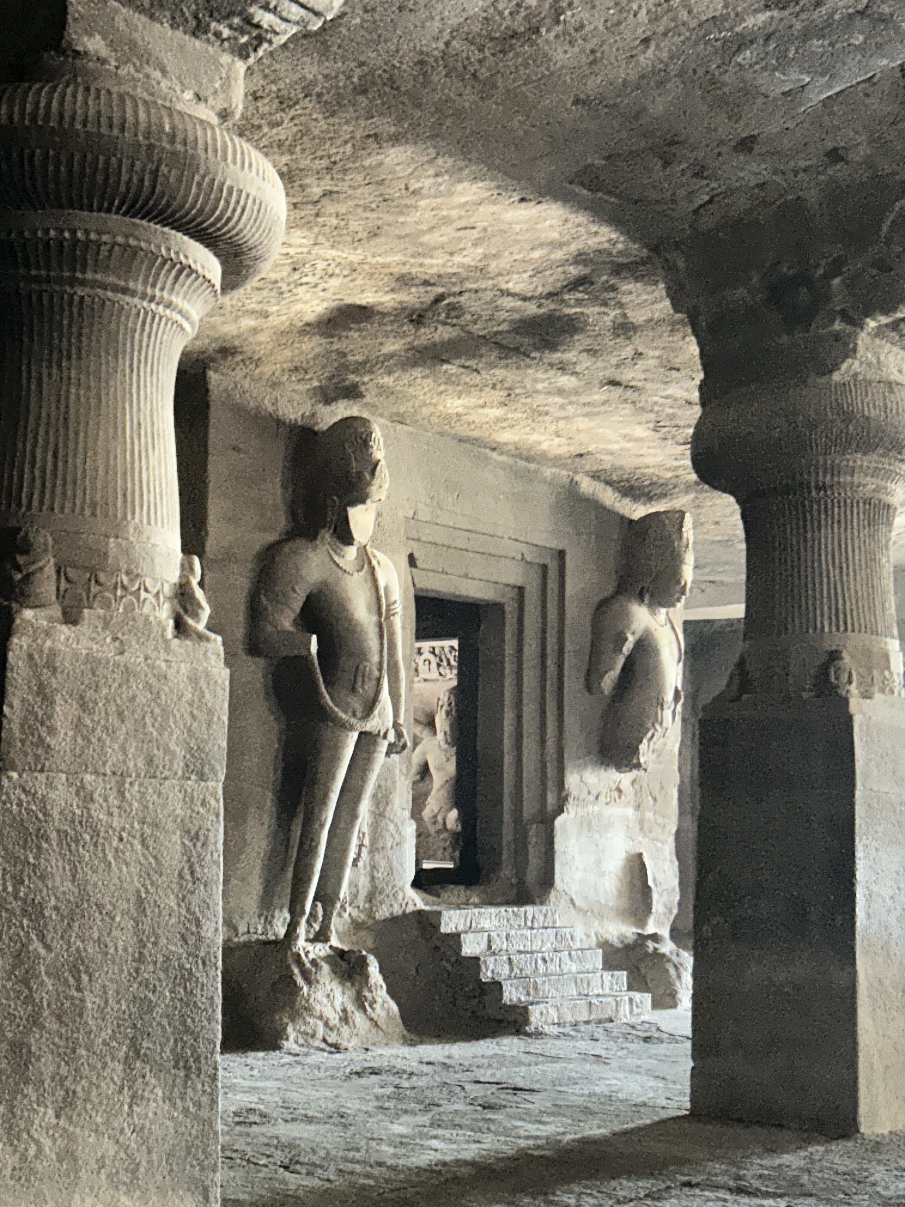 Ancient rock-cut guardian sculptures and stone pillars inside Elephanta Caves visited on a premium speedboat tour from Mumbai