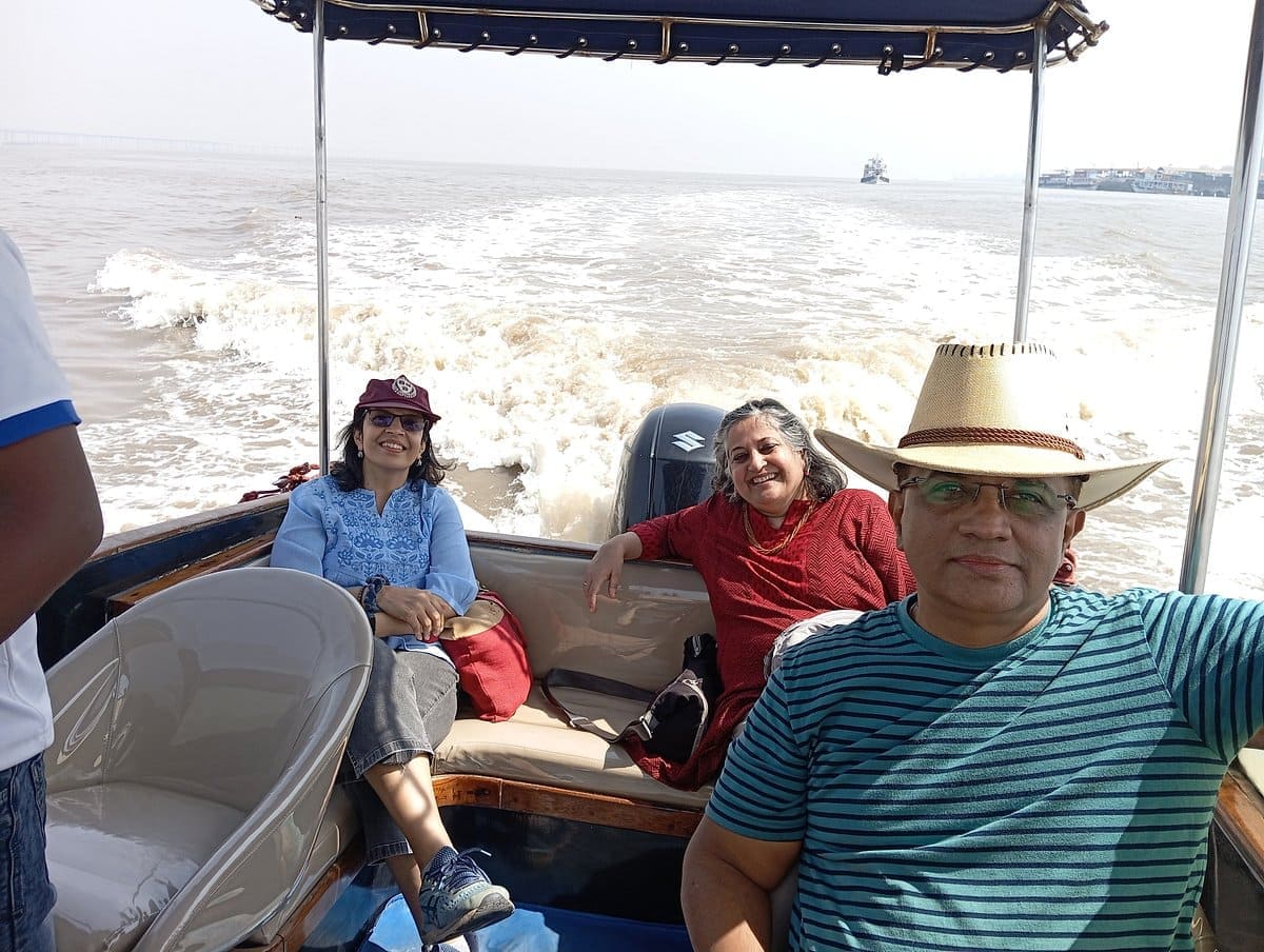 Tourists smiling aboard a speedboat while traveling from Mumbai to Elephanta Caves