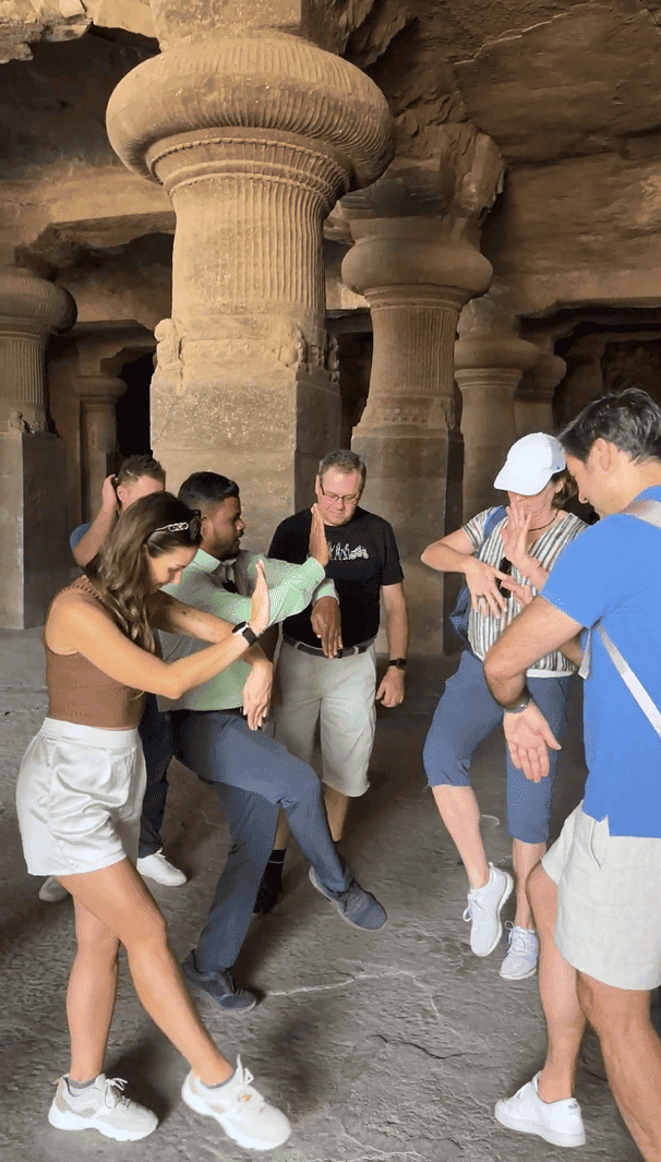 Group of travelers enjoying a joyful cultural moment inside Elephanta Caves complex